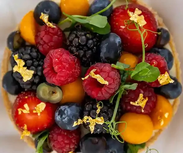 Une tartelette gourmande aux fruits rouges frais et éclats d'or, à déguster au restaurant Le Solstice à Cassis.