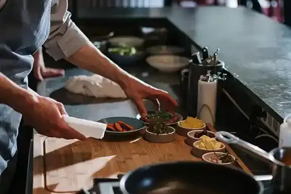 Chef ajoutant les derniers ingrédients sur un plat au restaurant Le Solstice à Cassis.